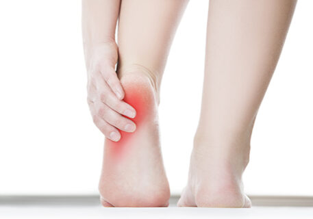 Pain in the foot. Massage of female feet. Pedicures. Isolated on white background.